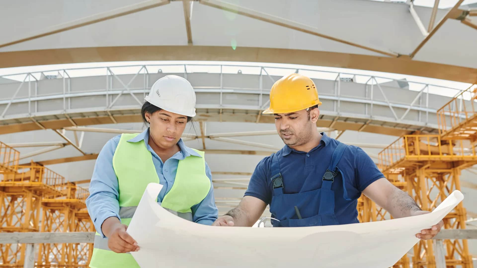 HSE consultant and site engineer reviewing drawings together on site
